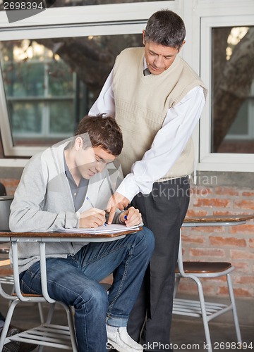 Image of Teacher Explaining Test To Student In Classroom
