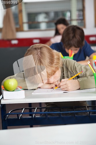 Image of Tired Schoolboy Sleeping At Desk