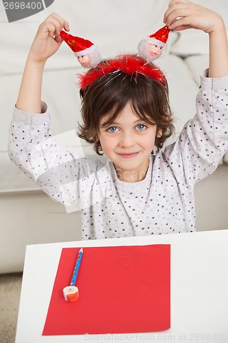 Image of Boy With Cardpaper And Pencil Holding Santa Headband