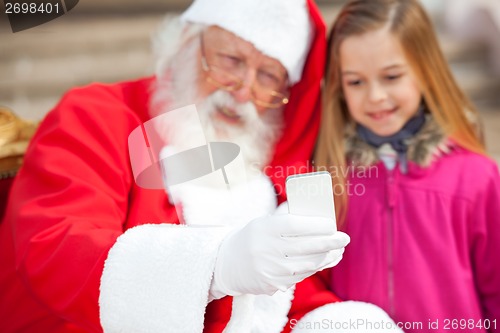 Image of Santa Claus And Girl Taking Selfportrait Through Smartphone