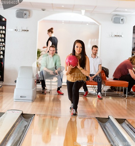Image of Woman Holding Bowling Ball in Club