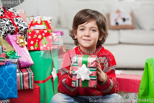 Image of Smiling Boy Holding Christmas Gift At Home