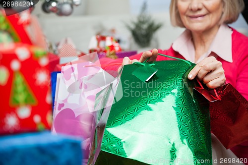 Image of Senior Woman Holding Bags During Christmas