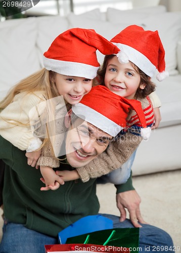 Image of Father Piggybacking Children During Christmas