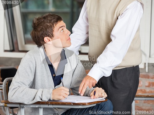 Image of Teacher Explaining Test To Student In Classroom