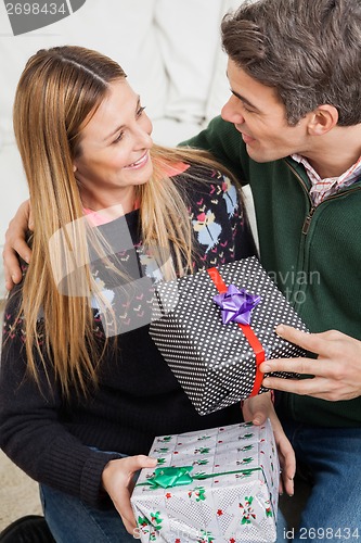 Image of Couple With Christmas Presents Looking At Each Other