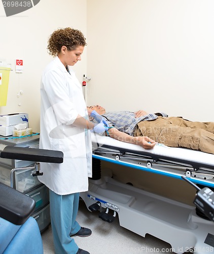 Image of Doctor Tying Strap On Patient's Arm Before Blood Test