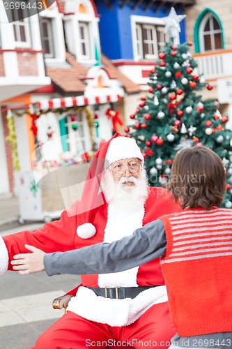 Image of Boy And Santa Claus About To Embrace