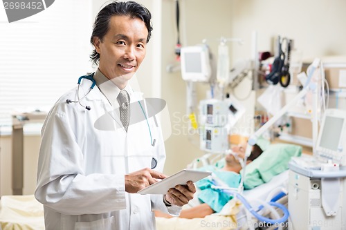 Image of Doctor With Digital Tablet Examining Patient's Test Report