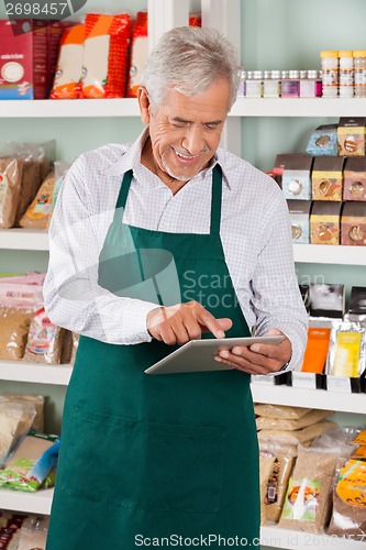 Image of Male Owner Using Tablet In Supermarket