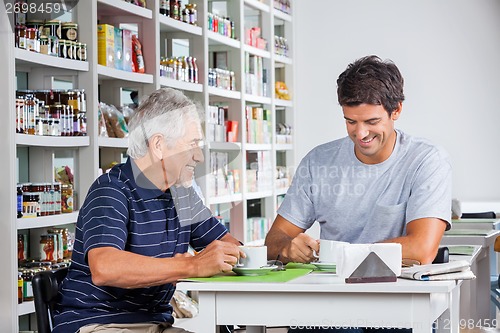 Image of Father And Son Having Coffee At Table