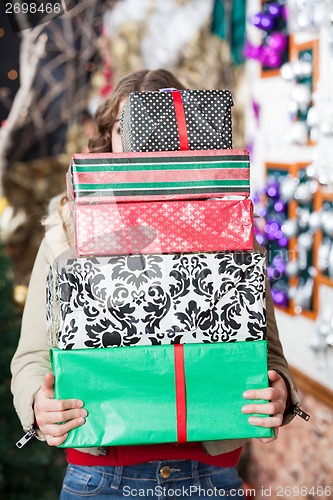 Image of Woman Hiding Behind Stack Of Christmas Gifts