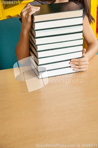 Image of Student With Stacked Books At Table In College Library