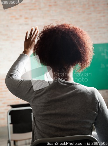 Image of Female Student Raising Hand To Answer In Classroom