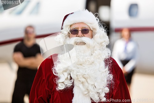 Image of Santa Standing Against Private Jet