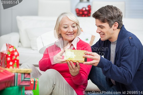 Image of Son Giving Christmas Gift To Mother