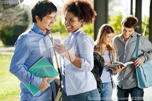 Image of Happy Friends With Mobilephone And Book In Campus