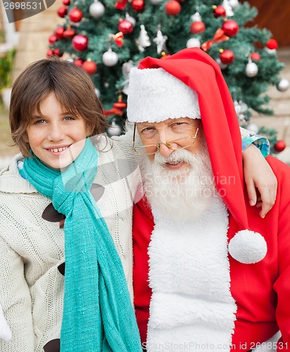 Image of Happy Boy With Arm Around Santa Claus