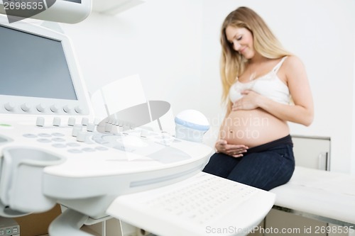 Image of Pregnant Woman Sitting By Ultrasound Machine