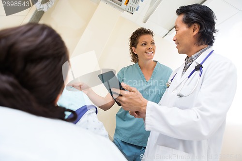 Image of Medical Team With Digital Tablet In Examination Room