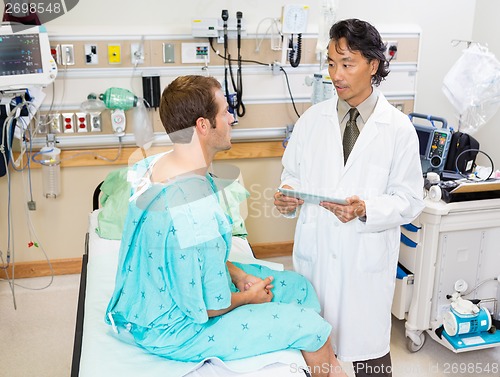 Image of Doctor Holding Digital Tablet While Discussing Report With Patie