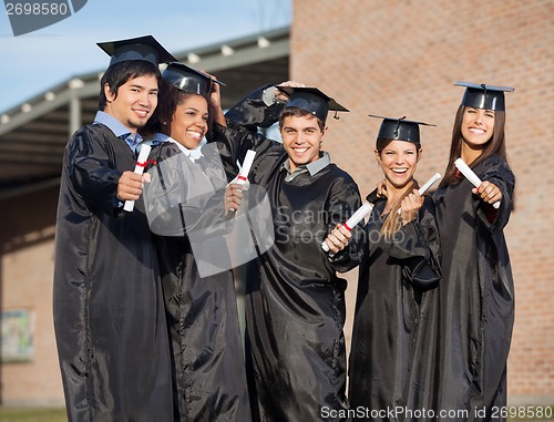 Image of Graduate Students Holding Certificates On University Campus