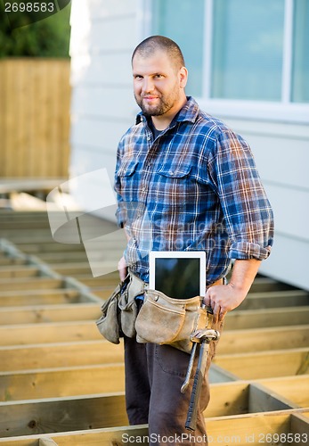 Image of Worker With Digital Tablet And Hammer In Tool Belt At Site