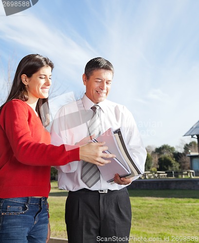 Image of Teacher And Student With Books Standing On Campus