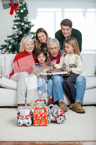 Image of Family Looking At Book In House