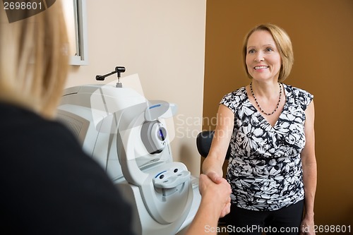 Image of Optician And Patient Shaking Hands In Clinic