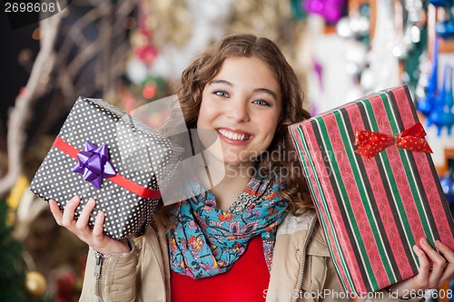 Image of Woman Holding Christmas Presents In Store
