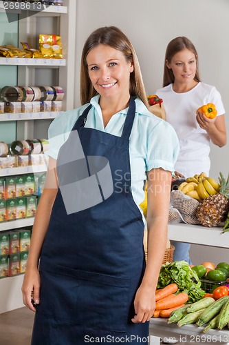 Image of Saleswoman With Female Customer Shopping In Background