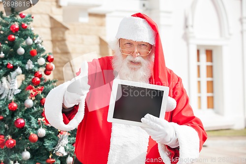 Image of Santa Claus Gesturing Thumbsup While Holding Digital Tablet