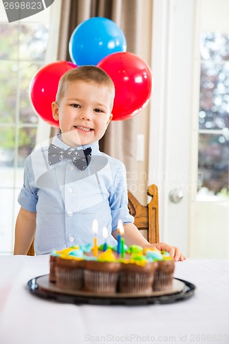 Image of Happy Boy Sitting In Front Of Birthday Cake