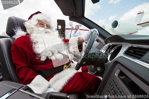 Image of Santa Driving Convertible At Airport Terminal