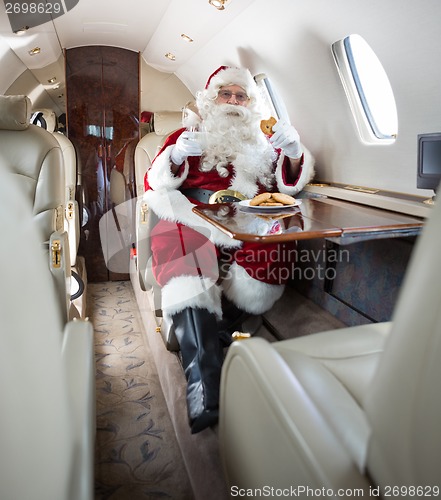 Image of Santa Having Cookies And Milk In Private Jet