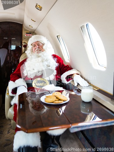Image of Santa With Eyes Closed Relaxing In Private Jet