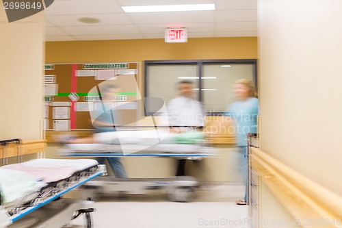 Image of Doctor And Nurses With Stretcher In Hospital Corridor