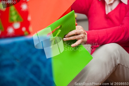 Image of Senior Woman With Bags Sitting On Floor