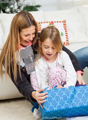 Image of Mother And Girl Opening Christmas Present