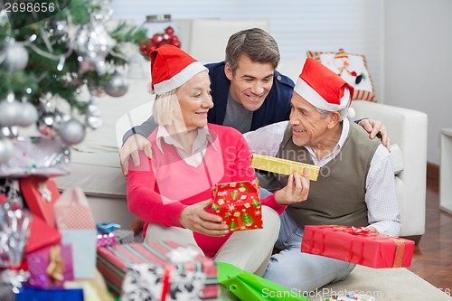 Image of Happy Parents And Son With Christmas Presents