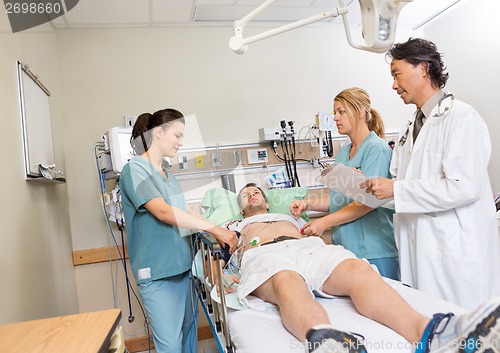 Image of Doctor And Nurses Checking Patient In Hospital