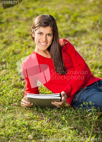 Image of Woman With Books Relaxing On Grass At College Campus