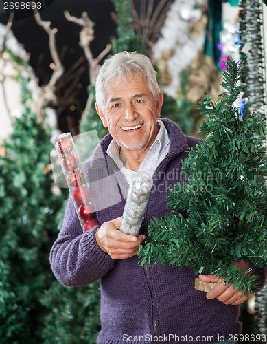 Image of Man Holding At Christmas Tree And Baubles In Store