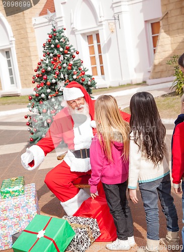 Image of Santa Claus Gesturing While Looking At Girl