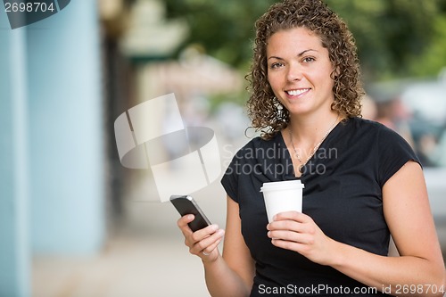 Image of Happy Woman With Coffee Cup Using Smartphone