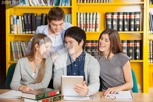 Image of College Friends With Digital Tablet Studying In Library