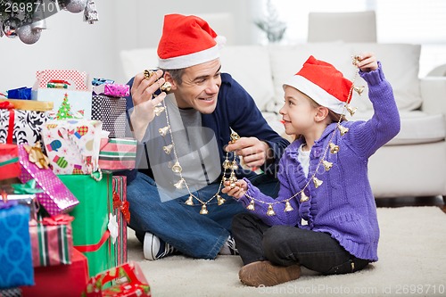 Image of Father And Daughter Holding Christmas Ornaments