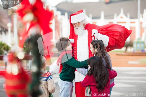 Image of Children Embracing Santa Claus