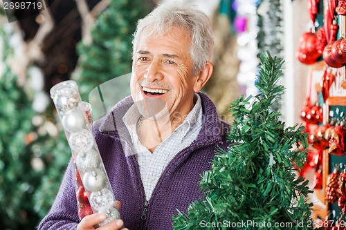 Image of Man Holding Bauble Packet In Store